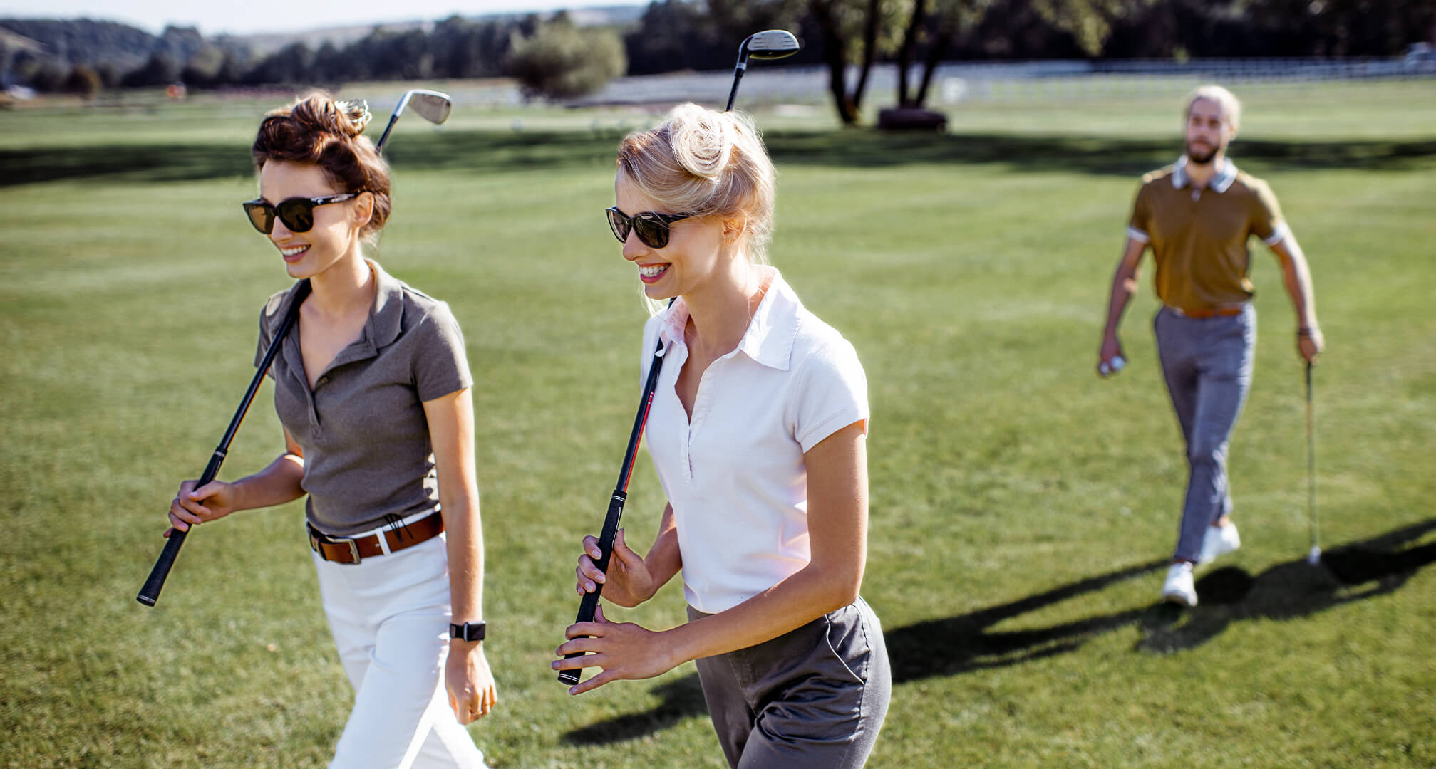 dvaja ľudia hrajúci golf so slnečnými okuliarmi